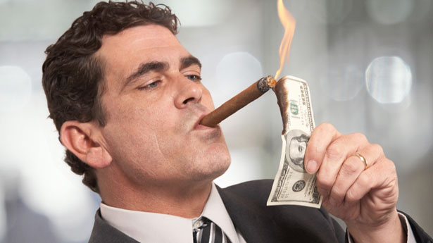 Rich-Businessman-Lighting-Cigar-With-100